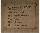 A handwritten weekly schedule taped to the community-room wall.