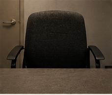 An empty institutional chair facing a closed door