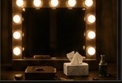 A dressing-room mirror surrounded by warm bulbs.